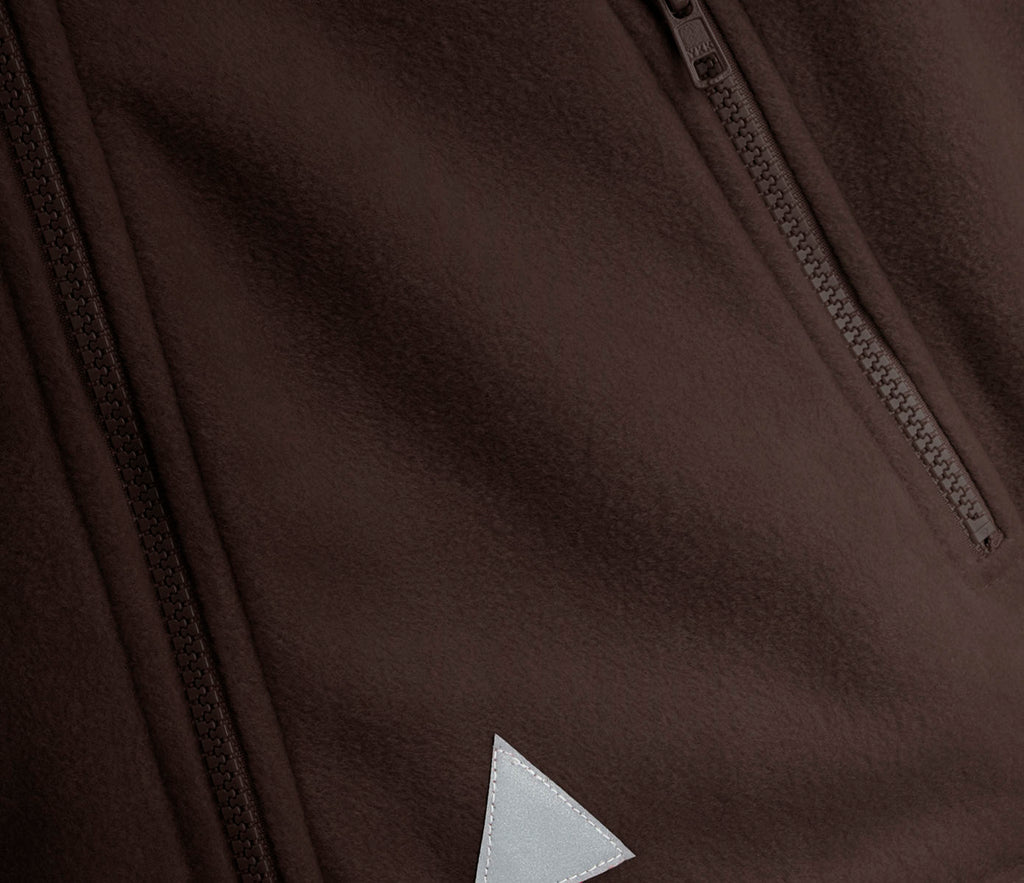 Zeco Polar Fleece - Brown, showing close-up of fleece fabric with two zippered pockets, triangular reflective patch, and elasticated cuffs for added functionality.