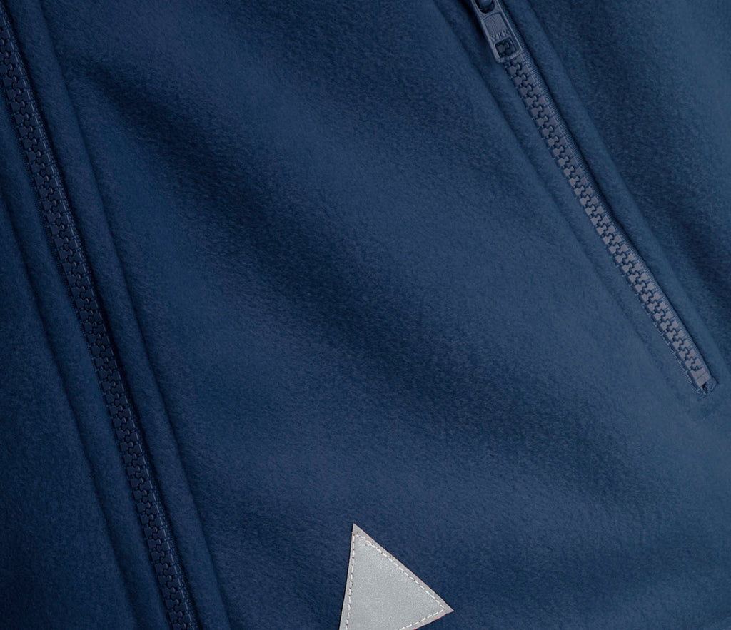 Close-up of Zeco Polar Fleece - Navy, featuring vertical zip pockets with YKK zips and a triangular reflective patch on heavyweight anti-pill fabric.