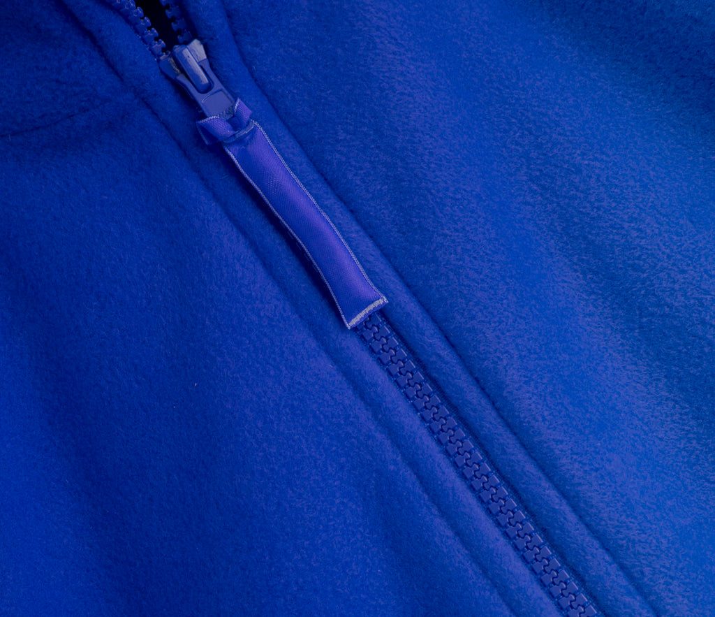 Close-up of Zeco Polar Fleece - Royal Blue, showcasing the soft-textured fleece, partially visible YKK zipper, and fabric pull tab.