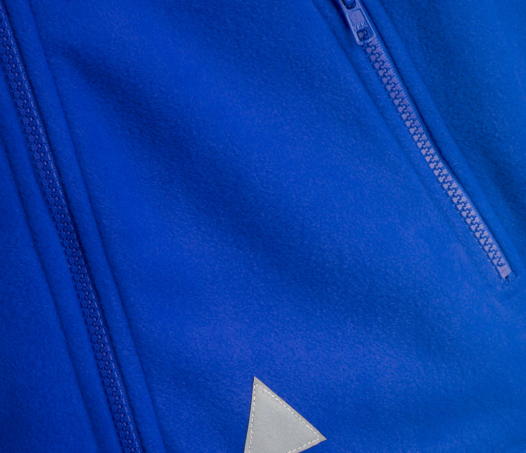 Zeco Polar Fleece - Royal Blue features visible zippered seams and a gray reflective patch, showcasing its full zip fastening and front zip pockets.